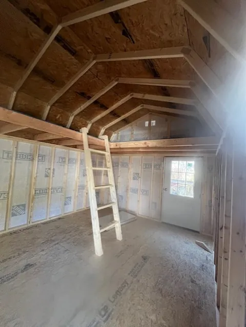 Bare stud-framed vaulted ceiling loft room before spray foam insulation is applied